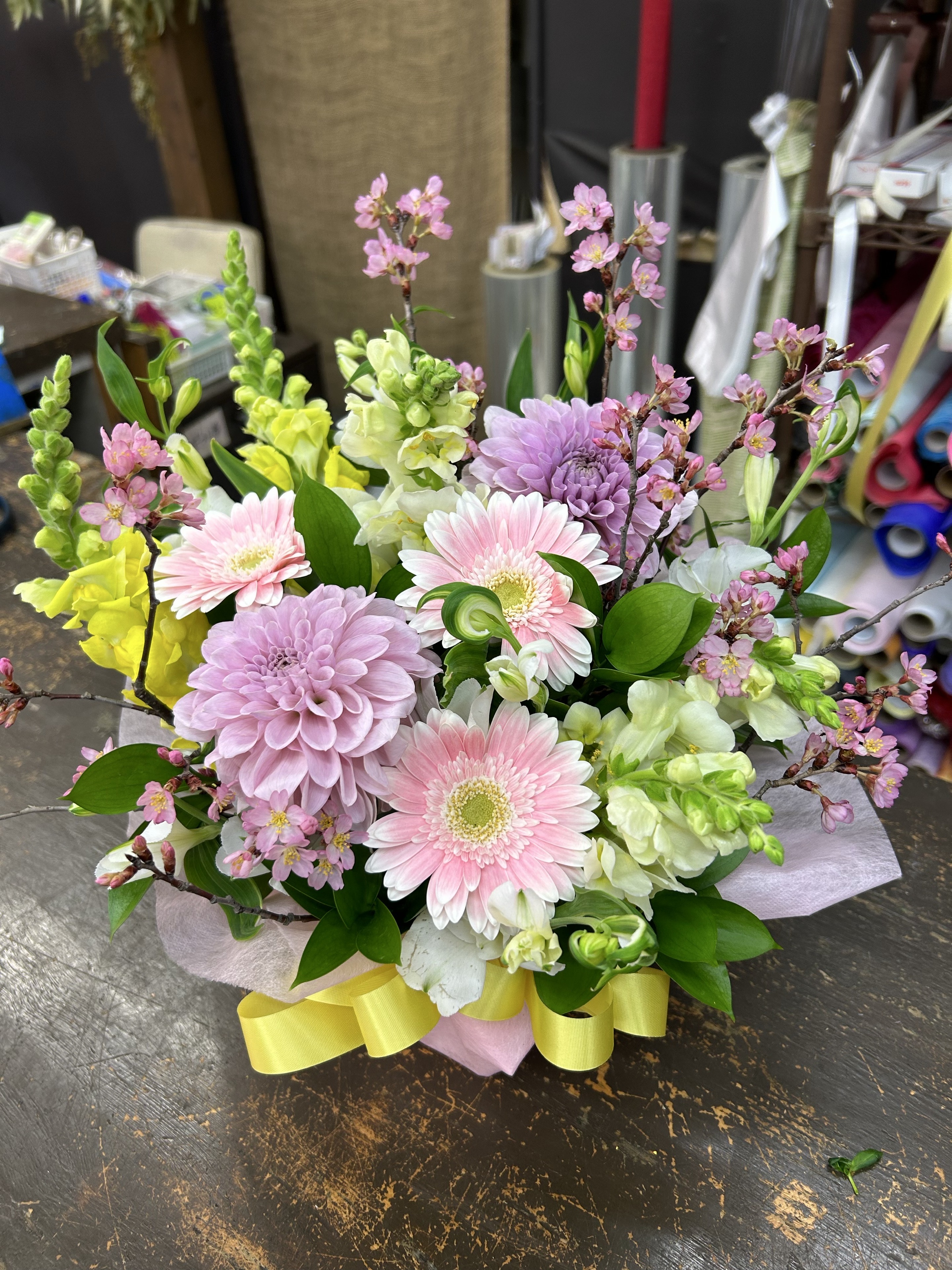 淡いピンクと紫、黄緑の花のアレンジメント