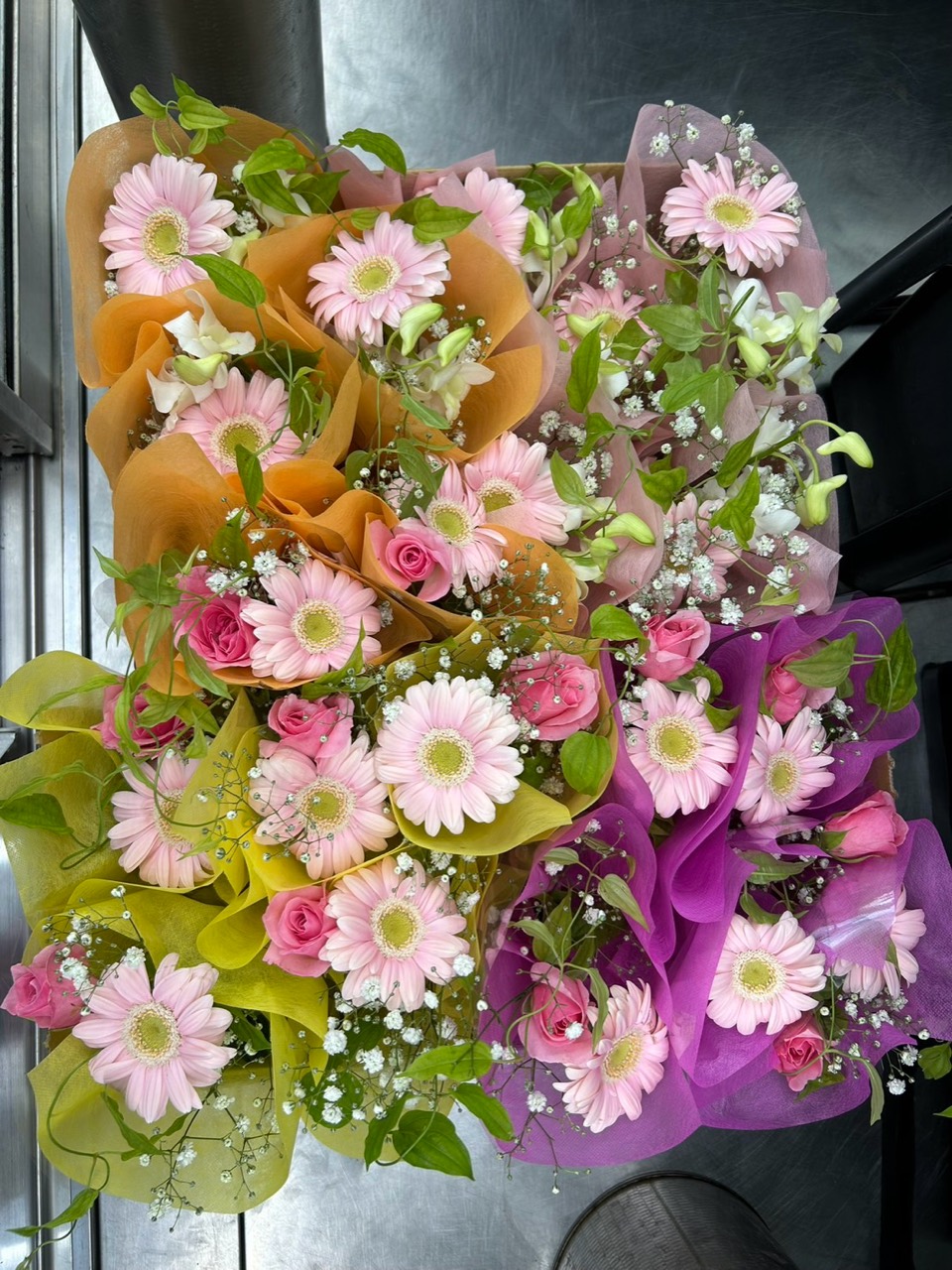ピンクの花を使った花束が並ぶ様子